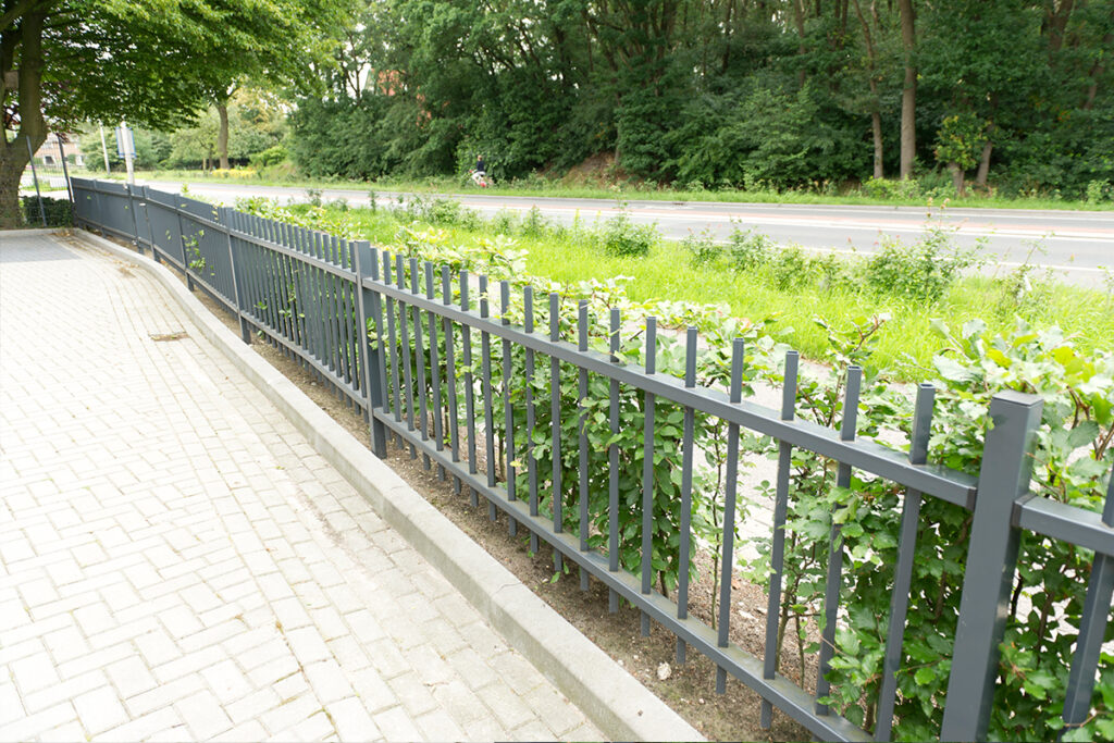 Stalen spijlenhekwerk langs een voortuin