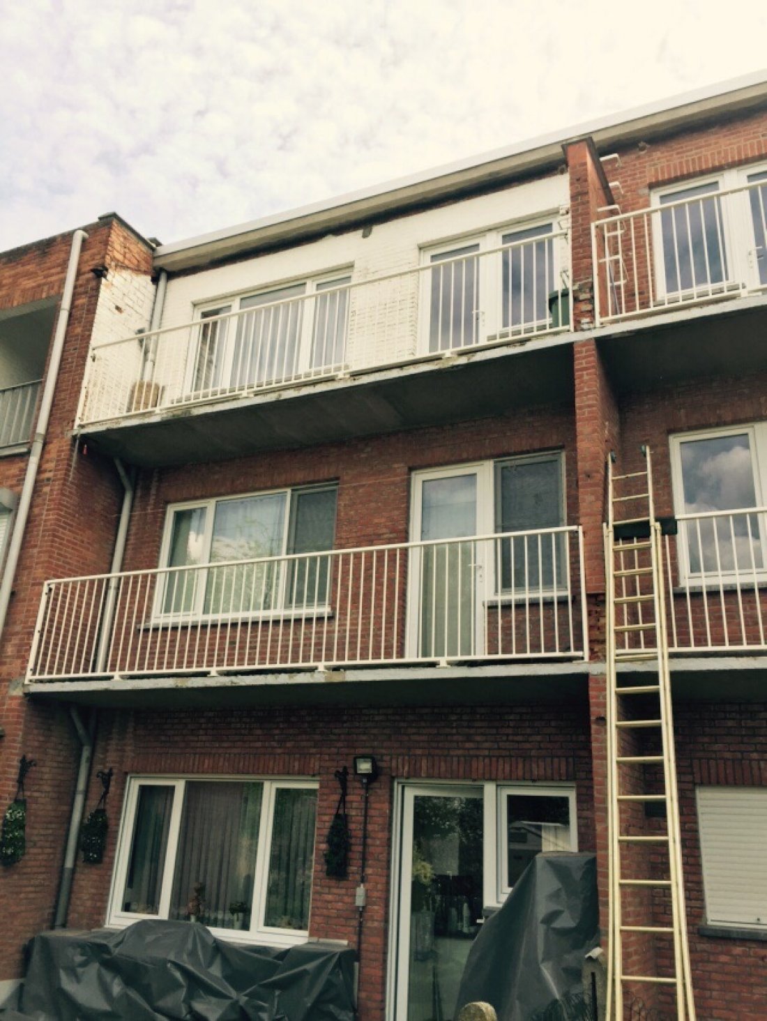 Stalen balustrade langs een betonnen galerij