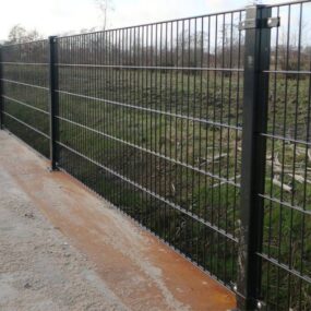 Dubbelstaafmat hekwerk met vierkante palen tijdens plaatsing in de tuin