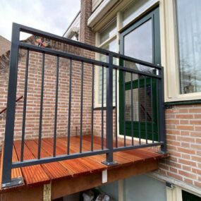 Balkon met beplanting langs een stalen hekwerk