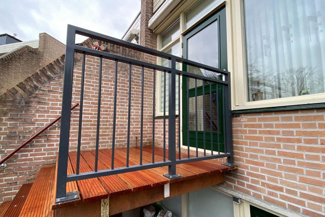 Balkon met beplanting langs een stalen hekwerk