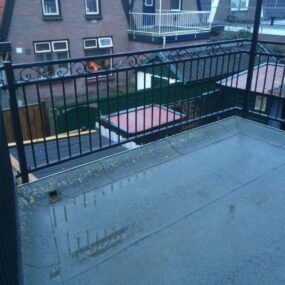 Stalen balustrade met houten handregel op een balkon