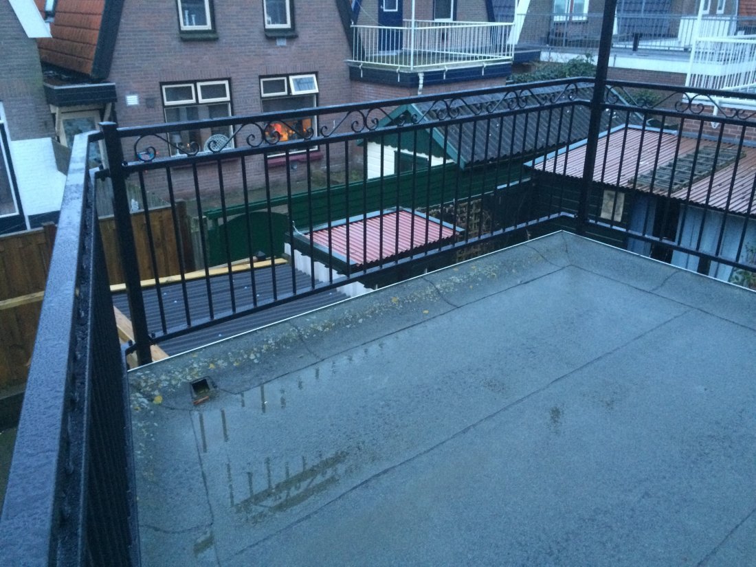 Stalen balustrade met houten handregel op een balkon