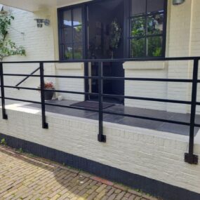 Stalen leuning met gevelbeugels aan de muur