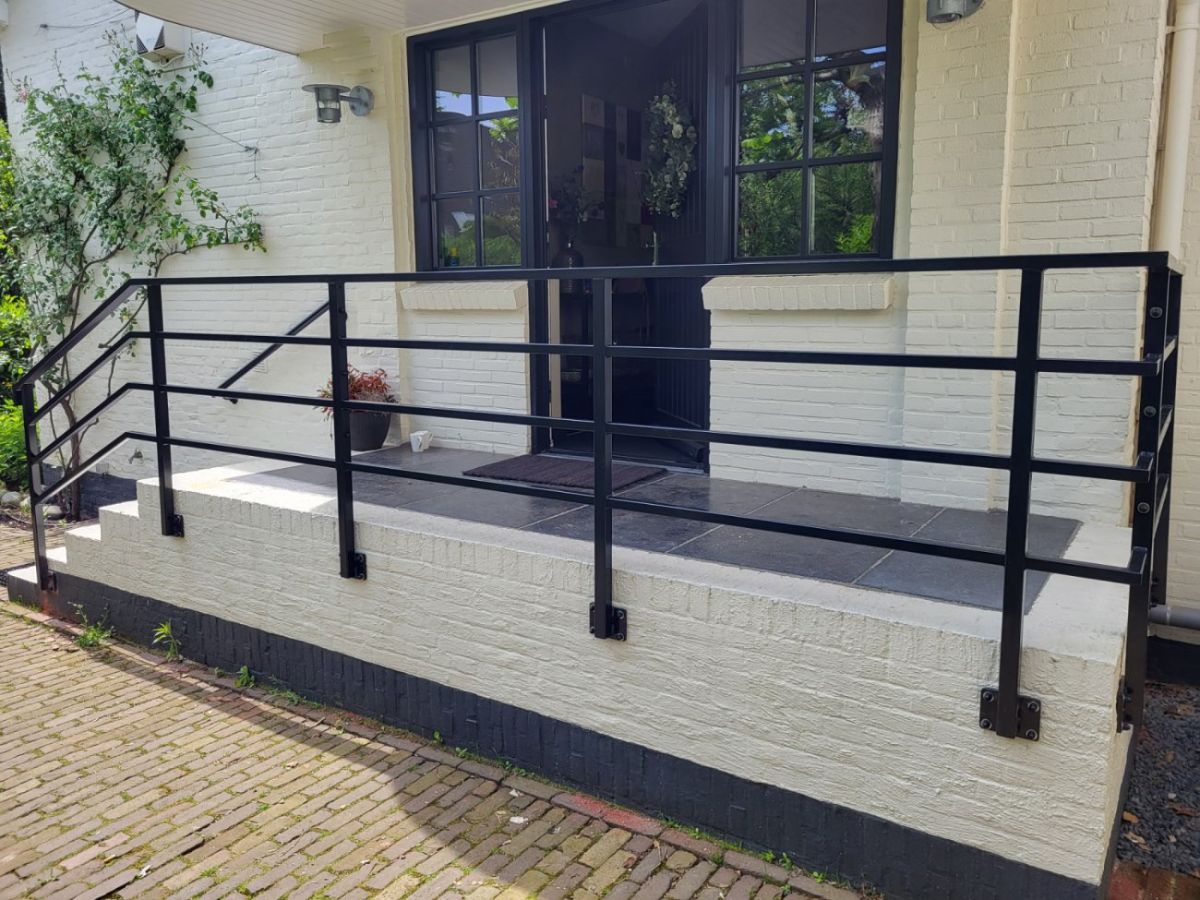 Stalen leuning met gevelbeugels aan de muur