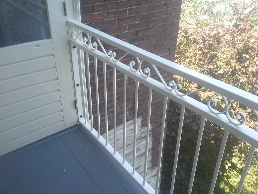 Antracietgrijze stalen balustrade langs een woning