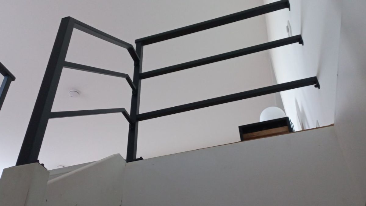 Stalen leuning langs een schuine wand