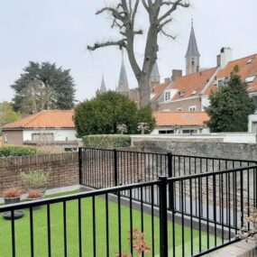 Stalen balustrade op een balkon met houten vloer