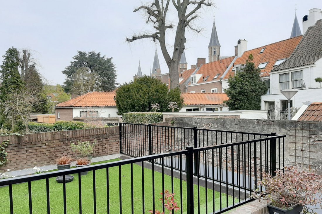 Stalen balustrade op een balkon met houten vloer